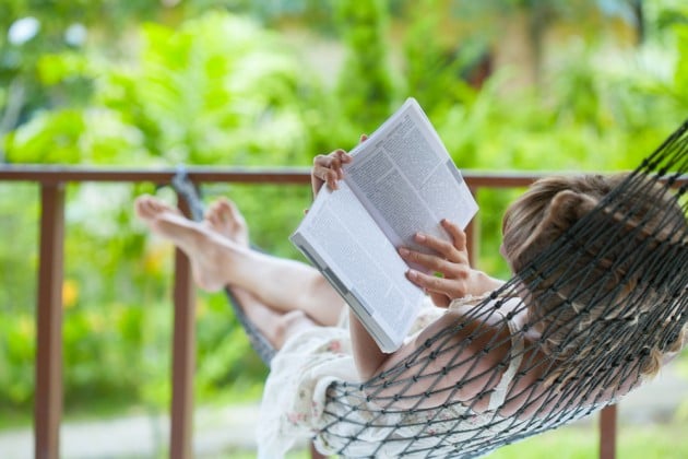 lady reading a book relaxing in a hammock