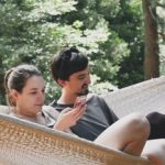 2 people relaxing in 2 person hammock with stand
