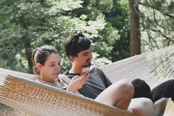 2 people relaxing in 2 person hammock with stand